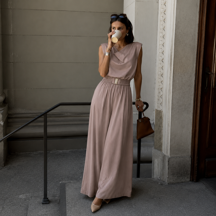 Beatriz – Ærmeløs jumpsuit med draperet halsudskæring og gyldent bælte